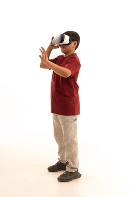 تعابير الاندماج والتركيز، التطور التقني والتكنولوجي، محاكاة العالم الخيالي والنظر الى الافلام الواقعيه،  بورتريه لولد عربي خليجي سعودي يرتدي الزي الكاجوال سروال وفانيلا حمراء ينظر من خلال نظارات ثلاثية الأبعاد (الفي ار),  الجسم بالطول الكامل، خلفيه بيضاء