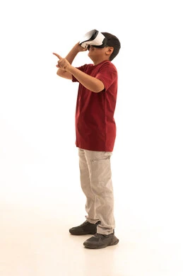 Simulation of the imaginary world and watching realistic movies, expressions of immersion and focus, technological and technical development, a portrait of a Saudi Arabian Gulf boy wearing traditional attire looking through 3D glasses (VR), full-body, white background.
