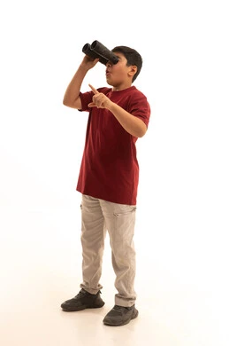 الاشارة لشيء ما باستخدام اليد ، رؤية الاشياء البعيدة عبر المنظار، التخطيط المستقبلي للأهداف والطموحات، بورتريه لولد عربي خليجي سعودي مبتسم يرتدي الزي الكاجوال يحمل بيده المنظار ثنائي العينين، حب الاستكشاف والمغامرة، الجسم بالطول الكامل، خلفية بيضاء