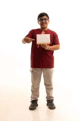 Marketing advertisements and promotions, use of explanatory informational boards, small white rectangular mockup, portrait of a smiling Arab Gulf Saudi boy wearing casual attire, red pants and t-shirt, holding a small empty rectangular white board in his hand, looking at the camera with gestures of joy and happiness, white background.
