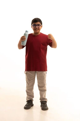 أهمية شرب الحليب عند الأطفال, إتباع نظام غذائي صحي, بورتريه لولد عربي خليجي سعودي مبتسم يرتدي الزي الكاجوال والنظارة الطبية يحمل بيده زجاجة حليب, مفهوم العناية والاهتمام بالصحة, خلفية بيضاء, جسم بالطول الكامل