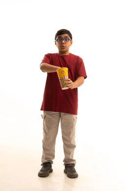 انشطة ترفيهية منزلية، مشاهدة الافلام والعروض المسرحية، بورتريه لولد عربي خليجي سعودي يرتدي الزي الكاجوال والنظارة الطبية يحمل بيده دلو الفشار، تناول الوجبات الخفيفة والسناك، الجسم بالطول الكامل، خلفية بيضاء