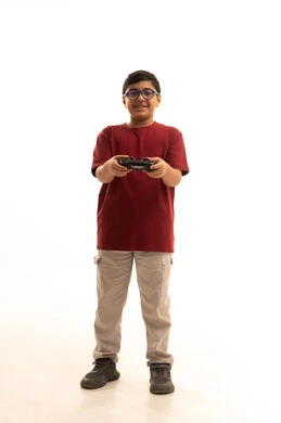 تجربة مثيرة في الأجهزة الحديثة الالكترونية، نشاطات ترفيهية ممتعة، التفاعل والاندماج مع ألعاب البلايستيشن, بورتريه لولد عربي خليجي سعودي يرتدي الزي الكاجوال والنظارة الطبية يحمل بيده عصا التحكم، الجسم بالطول الكامل، خلفية بيضاء