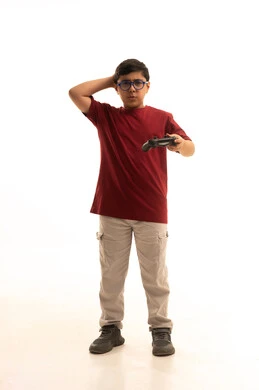 تجربة مثيرة في الأجهزة الحديثة الالكترونية، نشاطات ترفيهية ممتعة، التفاعل والاندماج مع ألعاب البلايستيشن, بورتريه لولد عربي خليجي سعودي يرتدي الزي الكاجوال والنظارة الطبية يحمل بيده عصا التحكم، الجسم بالطول الكامل، خلفية بيضاء