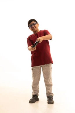 تجربة مثيرة في الأجهزة الحديثة الالكترونية، نشاطات ترفيهية ممتعة، التفاعل والاندماج مع ألعاب البلايستيشن, بورتريه لولد عربي خليجي سعودي يرتدي الزي الكاجوال والنظارة الطبية يحمل بيده عصا التحكم، الجسم بالطول الكامل، خلفية بيضاء