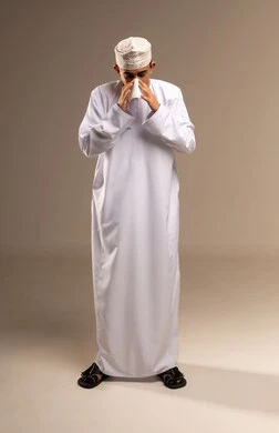 Nasal cavities and allergies, representing authentic Arab masculinity, an expression of fatigue and pain, a portrait of a Gulf Omani Arab man wearing a dishdasha and kumma, standing with his hand on his eye, the concept of caring about elegance and external appearance, maintaining traditional clothing, full-body, beige background.