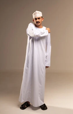 Shoulder grip and roughness, going to the doctor to treat pains, representing Arab masculinity, a portrait of an Omani Gulf Arab man wearing a dishdasha and kumma, the concept of caring about elegance and external appearance, maintaining traditional clothing, full-length body, beige background.