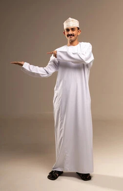 Something held in the hand, a gesture towards something, delicate feelings and emotions, representation of Arab masculinity, a portrait of a Gulf Arab Omani man wearing a dishdasha and kumma, the concept of caring about elegance and appearance, maintaining traditional dress, full-length body, beige background.
