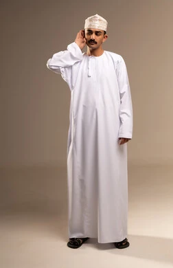 محاولة في توضيح السمع ، التعب وتحمل الالام ، الذهاب للطبيب لمعالجة الاوجاع، تمثيل الرجولة العربية،  بورتريه  لرجل عربي خليجي عماني يرتدي الدشداشة والكمة، مفهوم الاهتمام بالاناقة والمظهر الخارجي، المحافظة على لبس اللباس التقليدي، الجسم بالطول الكامل، خلفية بيج