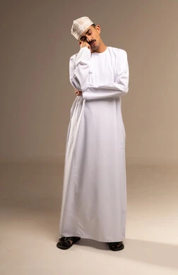 قيلولة قصيرة والشعور بالنعاس، التعب وتحمل الالام ، الذهاب للطبيب لمعالجة الاوجاع، تمثيل الرجولة العربية،  بورتريه  لرجل عربي خليجي عماني يرتدي الدشداشة والكمة، مفهوم الاهتمام بالاناقة والمظهر الخارجي، المحافظة على لبس اللباس التقليدي، الجسم بالطول الكامل، خلفية بيج