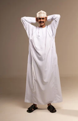Expressions of extreme fatigue and exhaustion, headache due to fatigue, hands resting on the head on the neck, tension and high blood pressure, the concept of elegance and masculinity, a portrait of an Arab Gulf Omani man wearing a dishdasha and kumma standing, attention to external appearance, full-length body, beige background.