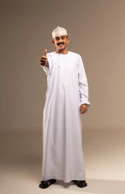 رفع إصبع الإبهام للأعلى دليل على الإعجاب، علامه الجوده تظهر عليه، ايماءات تدل على الموافقة والقبول، بورتريه لرجل عربي عماني  يرتدي الدشداشة والكمه تظهر عليه تعابير الفرح والسرور ، الرضى وعدم الرفض، الشعور بالقبول والرضا، الجسم بالطول الكامل، خلفية بيج