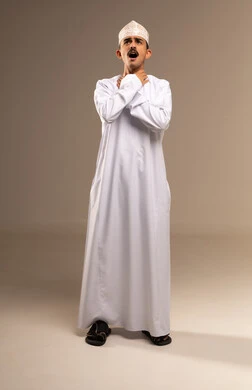 أمراض البلعوم والتهاب اللوزتين، عدم القدرة على التنفس والاحساس بالاختناق، الشعور بآلام في الحلق، بورتريه لرجل عربي خليجي عماني يرتدي الدشداشة والكمة يضع يديه حول عنقه بإيماءات المعاناة والتوجع، الجسم بالطول الكامل، خلفية بيج