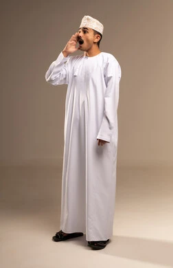 النداء بصوت مرتفع, ايماءات التحذير والمناداه، بورتريه لرجل عربي خليجي عماني يرتدي الدشداشة والكمه يقوم بمناداة شخص ما بايماءات الانصات والتركيز، إيماءات وجه ويدين تدل على المناداه,  تعابير وجه ويد تدلان على التنبيه من حدوث مصيبة ما، الجسم بالطول الكامل، خلفية بيج