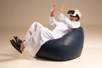 التفاعل والاندماج مع العالم الخيالي،  مشاهدة أفلام الواقع الافتراضي، استخدام التقنيات والتكنولوجيا المتطورة، بورتريه لشاب عربي خليجي عماني يرتدي الدشداشة والكمه العمانية يضع نظارة في آر على عينيه،قضاء أوقات الفراغ بشكل ممتع، خلفية بيج