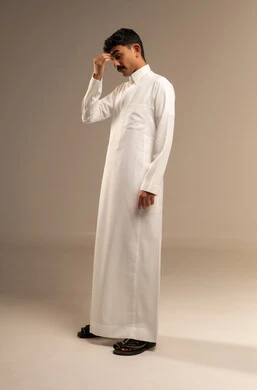 إيماءات محاولة تذكر أمر ما، بورتريه لرجل عربي خليجي سعودي يرتدي الزي التقليدي  يضع يده على راسه ينظر إلى الاسفل بتعابير التفكير،  التركيز والتمعن لإيجاد حل لمشكلة معينة، الجسم بالطول الكامل، خلفية رمادية.