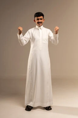 زيادة قدرة العضلات على التحمل، إتقان فنون الملاكمة، بورتريه لشاب عربي خليجي سعودي يرتدي الثوب التقليدي يرفع قبضة يديه بإيماءات القوة، ايماءات  و تعابير الثقة بالنفس، ممارسة رياضة الدفاع عن النفس، الجسم بالطول الكامل، خلفية رمادية
