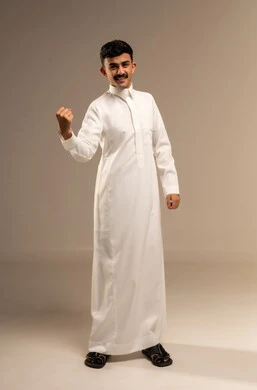 زيادة قدرة العضلات على التحمل، إتقان فنون الملاكمة، بورتريه لشاب عربي خليجي سعودي يرتدي الثوب التقليدي يرفع قبضة يديه بإيماءات القوة، ايماءات  و تعابير الثقة بالنفس، ممارسة رياضة الدفاع عن النفس، الجسم بالطول الكامل، خلفية رمادية