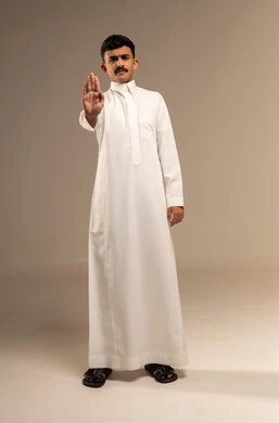 الأمر بالتوقف عن فعل شيء ما، تعابير الرفض والإمتناع، بورتريه لرجل عربي خليجي  سعودي يرتدي الثوب التقليدي  يرفع يده بإيماءات النهي، إيماءات الإنزعاج والغضب، الطول الكامل للجسم، خلفية  رمادية