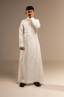 مشاكل عينيه وحالات مرضية، الحاجة للفحص والعلاج، مفهوم التهاب القرنية، بورتريه لشاب عربي خليجي سعودي  يضع يده على عينه بايماءات الألم، عدم القدرة على فتح العينين، خلفية رمادية