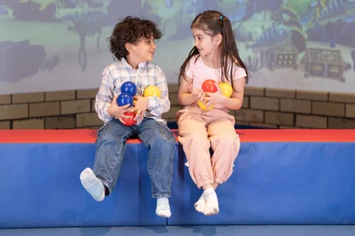 أجواء تفاعلية مبهجة ،قضاء الاوقات السعيده فى مدينه الالعاب ،بنت عربية خليجية إماراتية تستمتع بوقت ممتع في لعبة الرمي التفاعلية، برفقه اخوها ،مركز ألعاب ترفيهي، تعابير السرور والسعادة، لحظات المرح والحماس