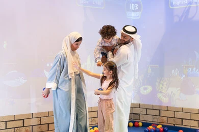 عائلة عربية خليجية إماراتية تستمتع بوقت ممتع في لعبة الرمي التفاعلية ،تعابير السرور والسعادة،  قضاء الاوقات السعيده مع الابناء ،مركز ألعاب ترفيهي، مشاركة الأب والأم أطفالهما لحظات المرح والحماس ، أجواء تفاعلية مبهجة