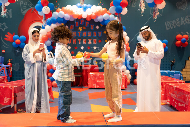 ايماءات المتعة والفرح، عائله عربيه خليجيه اماراتيه تستمتع باللعب فى مدينة الملاهي ، تلعب بالكور الملونه ، دمج التقنيات المتطوره فى الحياه اليوميه،  المراكز الترفيهيه المسلية في الامارات العربية،استخدام الجوال فى توثيق اللحظات التذكاريه ، مفهوم التسلية والترفيه،قضاء أوقات سعيده في أرض المرح