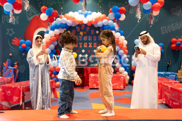 دمج التقنيات المتطوره فى الحياه اليوميه،  المراكز الترفيهيه المسلية في الامارات العربية،استخدام الجوال فى توثيق اللحظات التذكاريه ، مفهوم التسلية والترفيه، مشاعر المتعة والفرح، قضاء أوقات سعيده في أرض المرح، عائله عربيه خليجيه اماراتيه تستمتع باللعب فى مدينة الملاهي ، تلعب بالكور الملونه