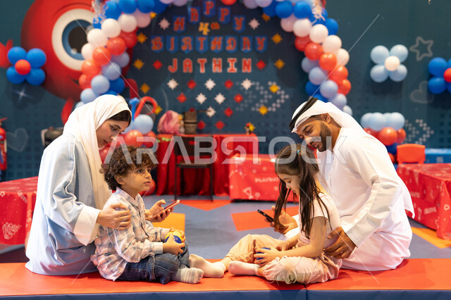مشاعر المتعة والفرح، قضاء أوقات سعيده في أرض المرح، المراكز الترفيهيه المسلية في الامارات العربية،عائله عربيه خليجيه اماراتيه تستمتع باللعب فى مدينة الملاهي ، تلعب بالكور الملونه وتستخدم الجوال ، مفهوم التسلية والترفيه، دمج التقنيات المتطوره فى الحياه اليوميه
