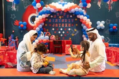 توثيق اللحظات التذكاريه ، المراكز الترفيهيه المسلية في الامارات العربية، قضاء أوقات سعيده في أرض المرح،بنت عربيه خليجيه اماراتيه تستمتع باللعب فى مدينة الملاهي برفقه عائلتها وتستخدم الجوال ، مشاعر المتعة والفرح، مفهوم التسلية والترفيه، دمج التقنيات المتطوره فى الحياه اليوميه