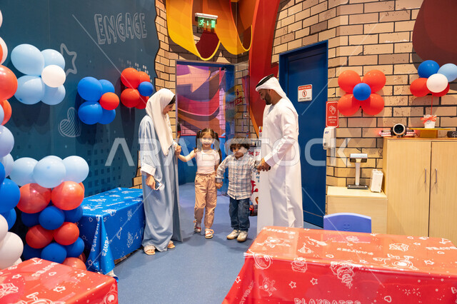 Amusement centers in the UAE, spending happy times in the land of fun, an Arab Gulf Emirati family enjoying playing in the amusement park, feelings of fun and joy, the concept of entertainment and fun, enjoyable recreational activities