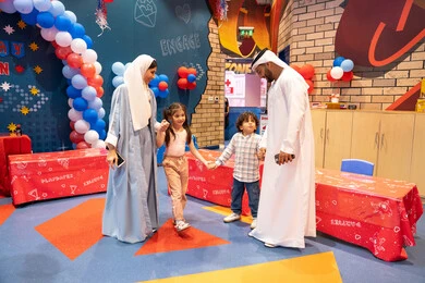 Spending happy times in the land of fun, an Arab Gulf Emirati family enjoying playing in the amusement park, feelings of fun and joy, the concept of entertainment and amusement, entertaining entertainment centers in the United Arab Emirates, fun entertainment activities