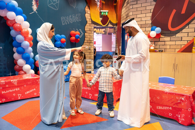 ام اماراتيه تشير الى مكان ما ،المراكز الترفيهيه المسلية في الامارات العربية،قضاء أوقات سعيده في أرض المرح، عائله عربيه خليجيه اماراتيه تستمتع باللعب فى مدينة الملاهي،مفهوم التسلية والترفيه، مشاعر المتعة والفرح،الانشطة الترفيهية الممتعه