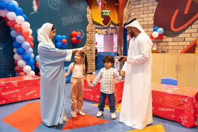 Emirati mother pointing to a place, fun entertainment centers in the UAE, having a good time in the land of fun, an Arab Gulf Emirati family enjoying playing in an amusement park, the concept of entertainment and recreation, feelings of pleasure and joy, enjoyable recreational activities