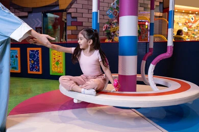 تنمية مهارات الأطفال، قضاء اوقات سعيده فى مدينه الالعاب، أجواء مليئة بالمرح والسعادة ، مفهوم التفاعل الأسري ، سيدة عربية خليجية إماراتية ترتدي العباءة والحجاب تشارك ابنتها لحظات ممتعة فى لعبة المراجيح الدوارة ذات الألوان الزاهية، تعابير الحب والاحتواء، مركز ألعاب ترفيهي في الإمارات، الاهتمام ودعم الابناء