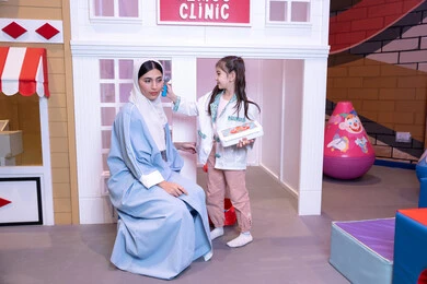 الطب والرعاية الصحية، الاستمتاع في مركز الالعاب الترفيهي، مفهوم التعليم عن طريق اللعب، تعريف الأطفال على المهن المستقبلية، أم إماراتية ترتدي عباءة تقوم باللعب مع ابنتها، فتاة عربية خليجية سعودية ترتدي الزي الطبي تقوم بمعالجه والدتها