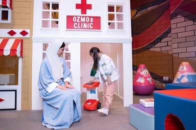 الطب والرعاية الصحية،مفهوم التعليم عن طريق اللعب، تعريف الأطفال على المهن المستقبلية، الاهتمام ودعم الابناء، قضاء اوقات مرحه في مركز الالعاب الترفيهي،  أم إماراتية ترتدي عباءة تقوم باللعب مع ابنتها،  فتاة عربية خليجية سعودية ترتدي الزي الطبي تقوم بمعالجه والدتها ،وسائل ايضاح تعليميه ممتعه