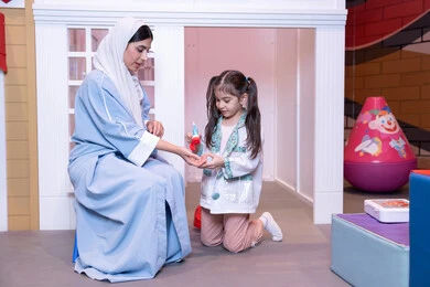 تعريف الأطفال على المهن المستقبلية، الاهتمام ودعم الابناء، قضاء اوقات مرحه في مركز الالعاب الترفيهي، الطب والرعاية الصحية، أم إماراتية ترتدي عباءة تقوم باللعب مع ابنتها،  فتاة عربية خليجية سعودية ترتدي الزي الطبي تقوم بمعالجه والدتها ،وسائل ايضاح تعليميه ممتعه ، مفهوم التعليم عن طريق اللعب