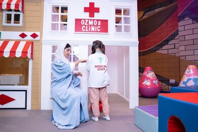 الطب والرعاية الصحية،  تعريف الأطفال على المهن المستقبلية، الاستمتاع في مركز الالعاب الترفيهي، مفهوم التعليم عن طريق اللعب،أم إماراتية ترتدي عباءة تقوم باللعب مع ابنتها، فتاة عربية خليجية سعودية ترتدي الزي الطبي تقوم بمعالجه والدتها