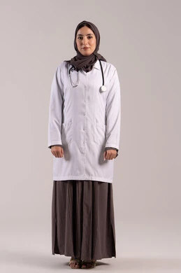 تقديم الرعاية الصحية والمساعدة للمرضى, مهن ووظائف نسائية, شابة سعودية تقوم بالعمل في المراكز والمستشفيات, بورتريه لطبيبة عربية خليجية اماراتية ترتدي المعطف الطبي الأبيض وسماعة الفحص تنظر إلى الكاميرا بايماءات الثقة بالنفس, مفهوم الطب والرعاية الصحية, الجسم بالطول الكامل, خلفية بنية