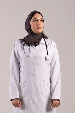 Support for patients with treatment and medical services, professions and jobs for women, a young Saudi woman working in clinics and hospitals, a portrait of an Arab Gulf Emirati doctor wearing a white medical coat and a stethoscope looking at something, the concept of medicine and healthcare, brown background.