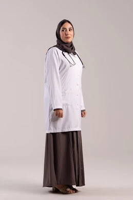 الوقوف بايماءات الثقة بالنفس, مهن ووظائف نسائية, تقديم المساعده الطبية للمرضى, شابة سعودية تقوم بالعمل في المراكز والمستشفيات, بورتريه من الجانب لطبيبة عربية خليجية اماراتية ترتدي المعطف الطبي الأبيض وسماعة الفحص, مفهوم الطب والرعاية الصحية, خلفية بنية