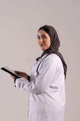 تطور القطاع الصحي في الامارات العربية, دمج التقنيات الحديثة بالمجالات الطبية،  سيده سعودية تقوم بتقديم الاستشارات للمرضى عن بعد الأجهزة التكنولوجية، بورتريه لطبيبة عربية خليجية اماراتية ترتدي المعطف الأبيض و السماعة تمسك جهاز التابلت ، خلفية بنية