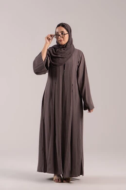 ارتداء النظارات الخاصة بضعف النظر, الاهتمام بالمظهر الخارجي، بورتريه لامرأة عربية خليجية اماراتية محجبة ترتدي عباءة تمسك بيدها نظارة طبية، تحسين الرؤية ومحاولة تعديل البصر، شابة سعودية انيقة،  الجسم بالطول الكامل ,خلفية بنية