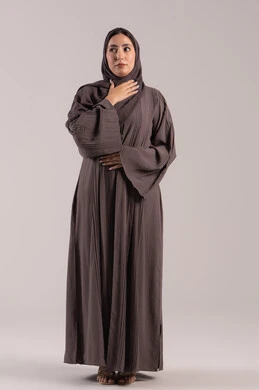 الإرهاق مع أعراض السعال، تعابير الالم والارهاق، الانفلونزا والتهاب الرئة، بورتريه لامرأة عربية خليجية اماراتية محجبة ترتدي عباءة تضع يدها حنجرتها بايماءات التوجع، شابة سعودية مريضة، خلفية بنية