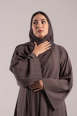 الانفلونزا والتهاب الرئة, الشعور بالمرض والكحة، تعابير الالم والارهاق، بورتريه لامرأة عربية خليجية اماراتية محجبة ترتدي عباءة تضع يدها حنجرتها بايماءات التوجع، شابة سعودية مريضة، خلفية بنية