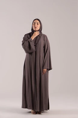 تعابير الالم والارهاق, الشعور بالمرض والكحة، الانفلونزا والتهاب الرئة، بورتريه لامرأة عربية خليجية اماراتية محجبة ترتدي عباءة تضع يدها حنجرتها بايماءات التوجع، شابة سعودية مريضة، الجسم بالطول الكامل, خلفية بنية