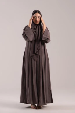 الرغبة في الاسترخاء والشعور بصداع الرأس، الإحساس بألم الرأس والصداع، المعاناة من آلام الشقيقة، بورتريه لإمرأة عربية خليجية اماراتية محجبة ترتدي عباءة تضع يديها على رأسها بايماءات التعب والارهاق، شابة سعودية مريضة، صورة الجسم بالطول الكامل، خلفية بنية