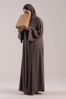 الإحساس بالمغص والوجع, إيماءات التقيؤ والغثيان، الحاجه للمساعدة وطلب العلاج، بورتريه لامرأة عربية خليجية إماراتية ترتدي العباءة تحمل بيدها كيس ورقي، شابة سعودية مريضة، الجسم بالطول الكامل,  خلفية بنية