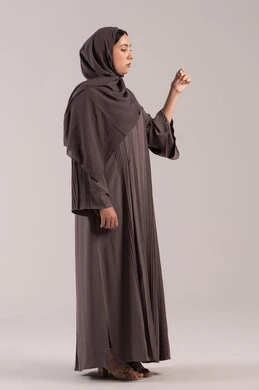 الحاجة للفحص الطبي ووضع برنامج علاجي, الشعور بالتعب والمرض, اتباع إجراءات السلامة والوقاية، الإصابة بالحمى والتعب، بورتريه من الجانب لامرأة عربية خليجية اماراتية محجبة ترتدي عباءة تحمل بيدها ميزان حرارة رقمي، شابة سعودية مريضة، الجسم بالطول الكامل, خلفية بنية